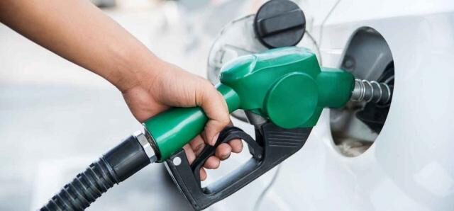 A green fuel pump nozzle refuelling a white car in South Africa